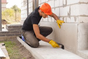 Worker plastering the home foundation
