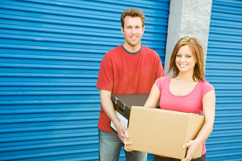 Couple carrying boxes to storage unit