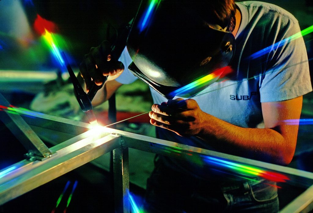 Man welding with colorful lights