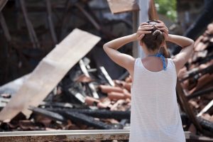 woman looking at her burnt home
