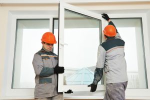two people installing a window
