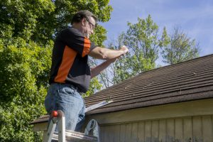 man checking roof for damages